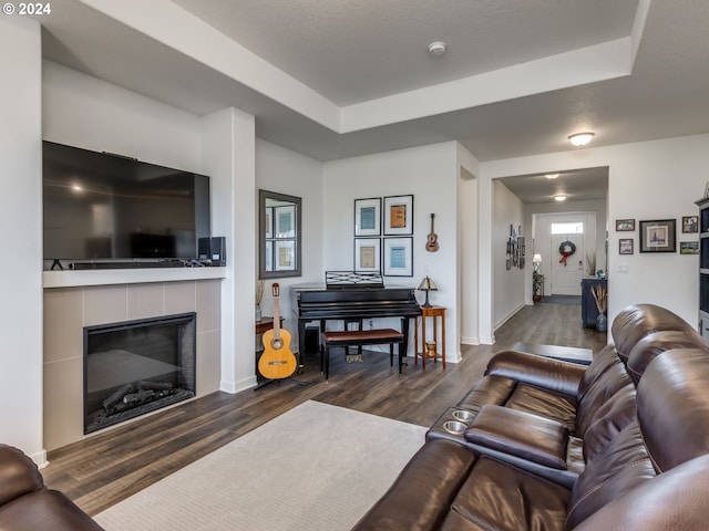 living room with dark hardwood / wood-style floors, a fireplace, and a tray ceiling