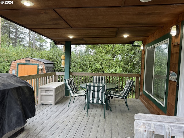 wooden terrace with a storage shed and grilling area