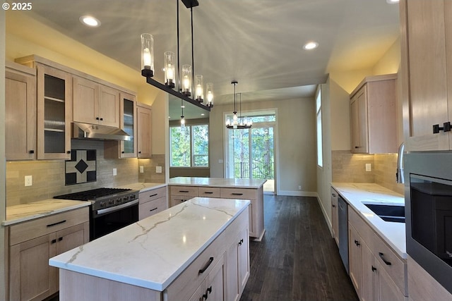 3404 River Heights Dr, Springfield, OR 97477 - kitchen with gas range, a peninsula, under cabinet range hood, stainless steel dishwasher, and baseboards