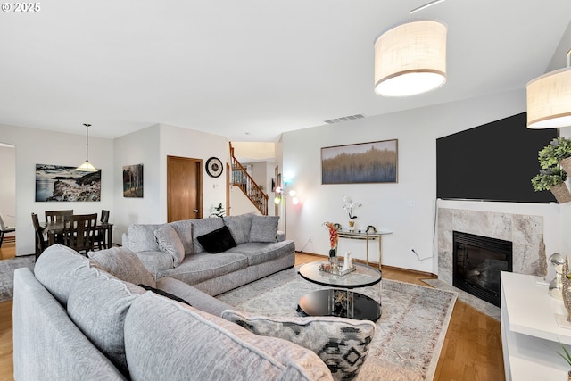 living room with light hardwood / wood-style floors and a premium fireplace