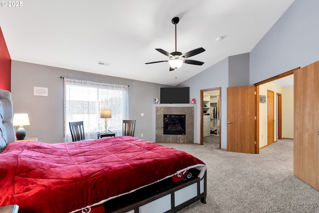 bedroom featuring vaulted ceiling, light carpet, a closet, ceiling fan, and a walk in closet