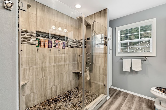 bathroom with toilet, hardwood / wood-style flooring, and a shower with door