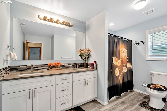 bathroom featuring toilet, vanity, decorative backsplash, and hardwood / wood-style floors