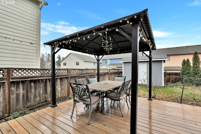 wooden deck featuring a storage unit and a gazebo