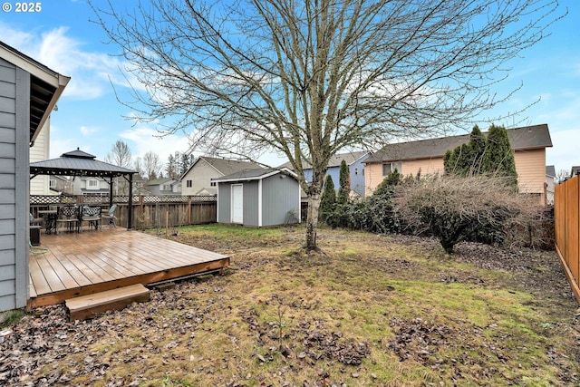 view of yard featuring a gazebo, a deck, and a storage unit