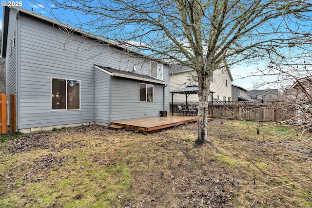 back of property featuring a gazebo and a wooden deck