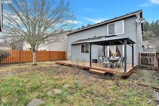 rear view of house featuring a wooden deck and a gazebo