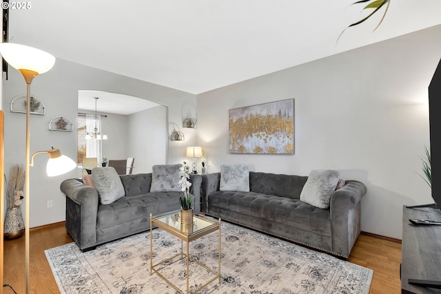 living room featuring a notable chandelier and light hardwood / wood-style flooring