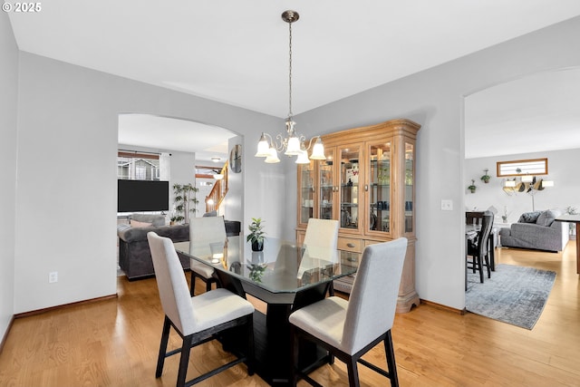 dining room featuring light wood-type flooring and an inviting chandelier