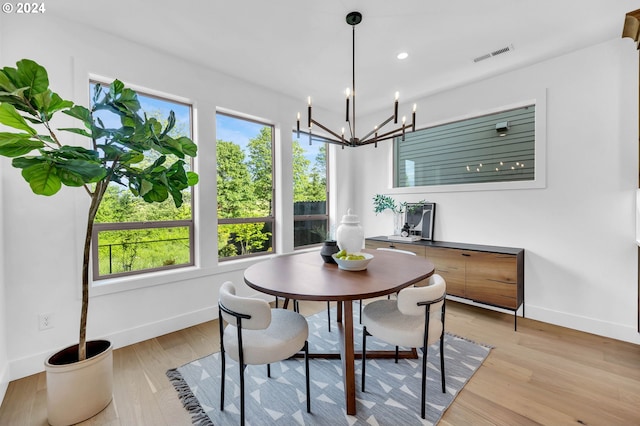 dining room featuring light wood-type flooring and a notable chandelier