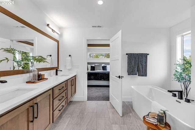 bathroom featuring a tub to relax in and vanity