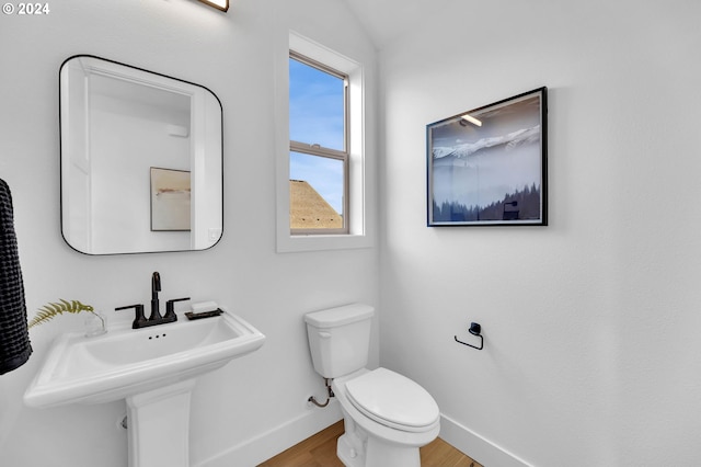 bathroom featuring toilet, lofted ceiling, hardwood / wood-style floors, and sink