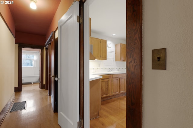 hallway featuring sink and light wood-type flooring