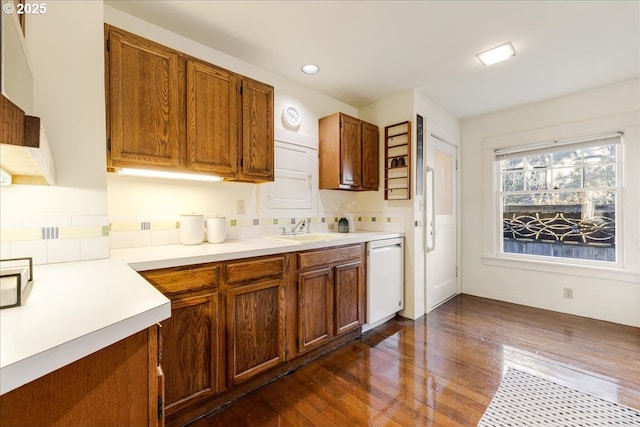 kitchen with sink, white dishwasher, and dark hardwood / wood-style floors