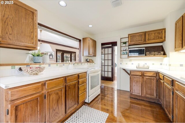 kitchen with decorative light fixtures, dark hardwood / wood-style flooring, white electric stove, and tasteful backsplash