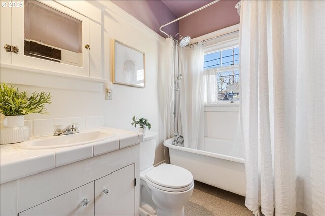 full bathroom with shower / tub combo with curtain, vanity, and toilet