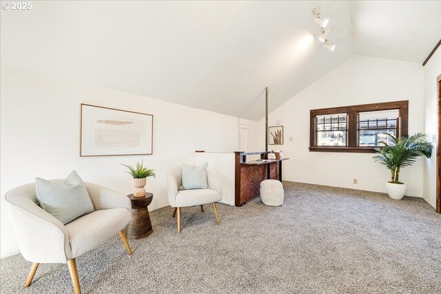 living area with rail lighting, carpet flooring, and lofted ceiling