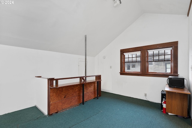 additional living space featuring dark carpet and vaulted ceiling