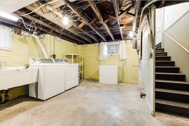 basement featuring sink, refrigerator, and washer and dryer