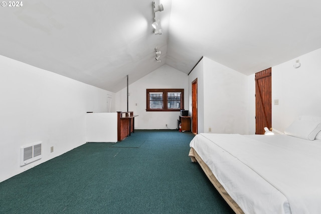 unfurnished bedroom featuring lofted ceiling, track lighting, and dark colored carpet