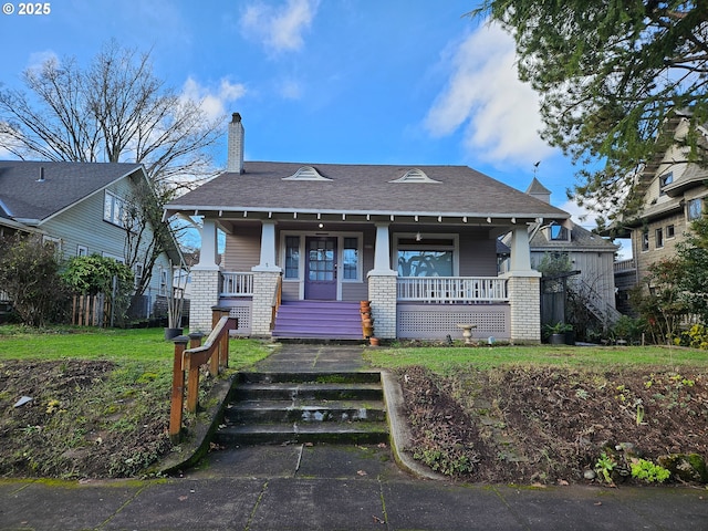 view of front of house with covered porch and a front lawn