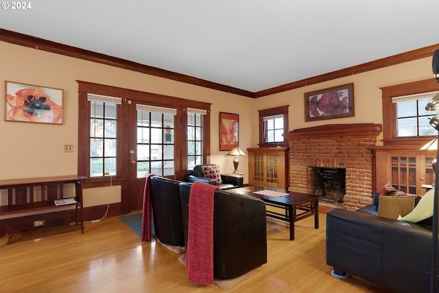 living room featuring ornamental molding, a fireplace, and light hardwood / wood-style floors