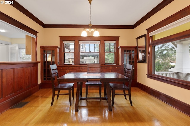 dining area featuring ornamental molding, a chandelier, and light hardwood / wood-style flooring