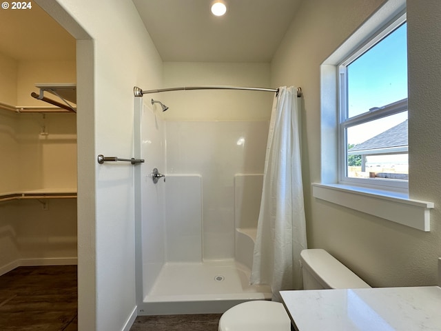 bathroom featuring toilet, wood-type flooring, vanity, and walk in shower