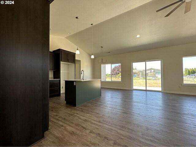 unfurnished living room with high vaulted ceiling, dark hardwood / wood-style floors, sink, and ceiling fan