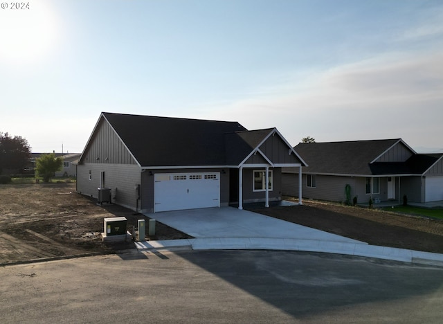 view of front of property featuring a garage and central air condition unit