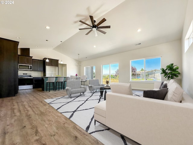 living room featuring high vaulted ceiling, ceiling fan, and light hardwood / wood-style flooring