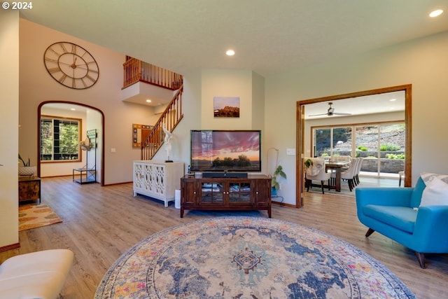 living area with stairs, plenty of natural light, wood finished floors, and recessed lighting