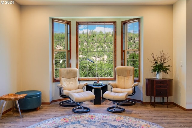 sitting room with baseboards and wood finished floors