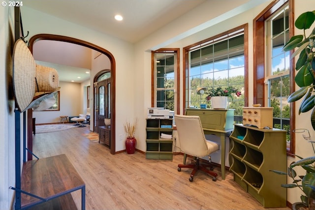 office featuring recessed lighting, light wood-style floors, baseboards, and arched walkways