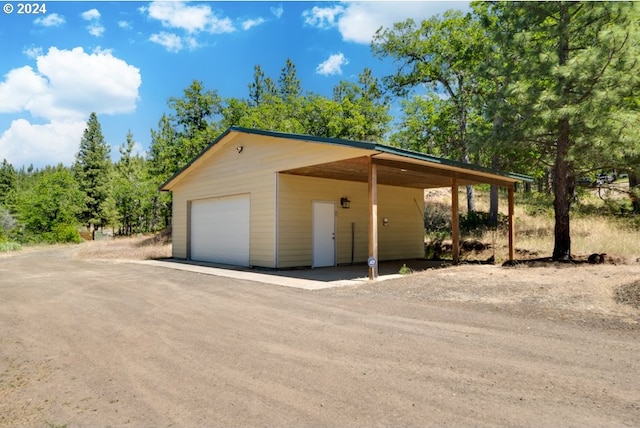 garage with a detached garage and dirt driveway