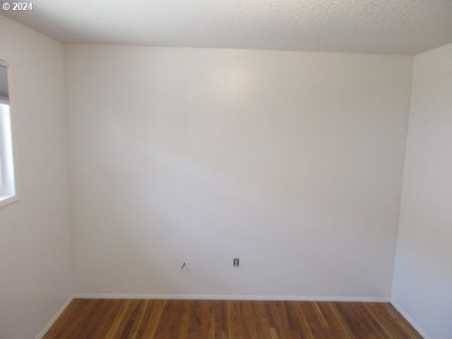 unfurnished room featuring hardwood / wood-style floors and a textured ceiling