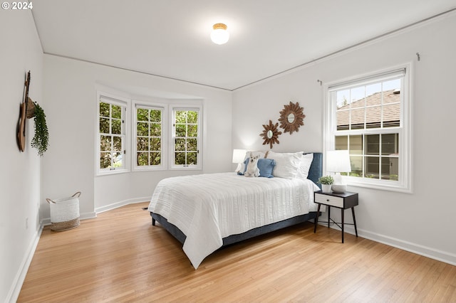 bedroom with wood-type flooring and crown molding