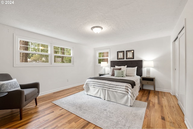 bedroom featuring a closet, a textured ceiling, and hardwood / wood-style flooring