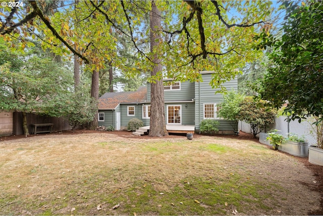 rear view of house featuring a lawn and a wooden deck