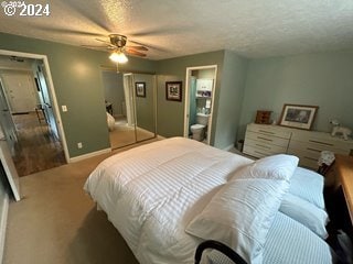 carpeted bedroom featuring ceiling fan, a closet, and a textured ceiling