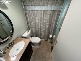 bathroom with walk in shower, tile patterned flooring, vanity, and toilet