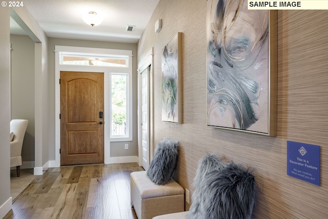 foyer entrance featuring light wood-type flooring and a textured ceiling