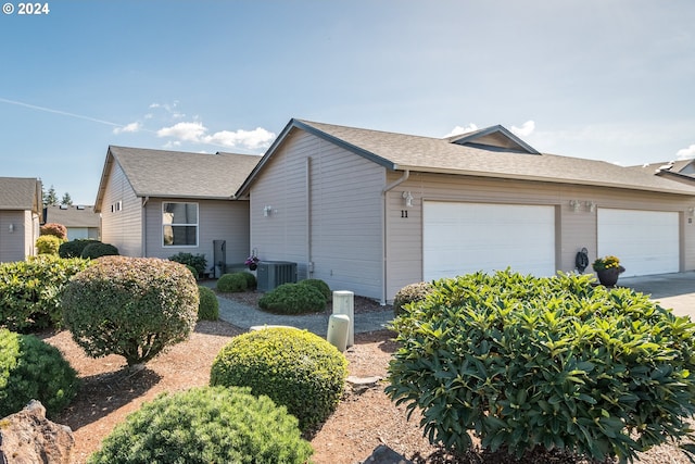 view of side of property with central AC unit and a garage