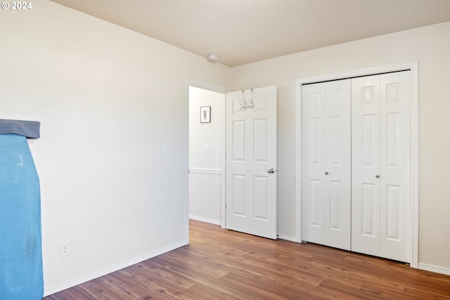 unfurnished bedroom with light wood-type flooring and a closet