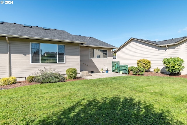 rear view of house featuring a yard and a patio