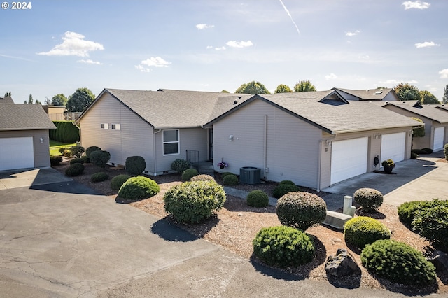 view of front of home with a garage and central AC