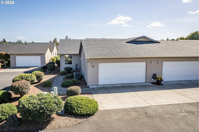 ranch-style house with cooling unit and a garage