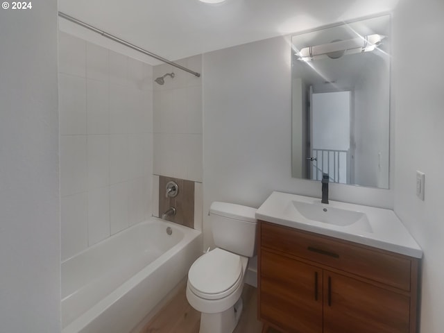 full bathroom featuring wood-type flooring, oversized vanity, toilet, and tiled shower / bath