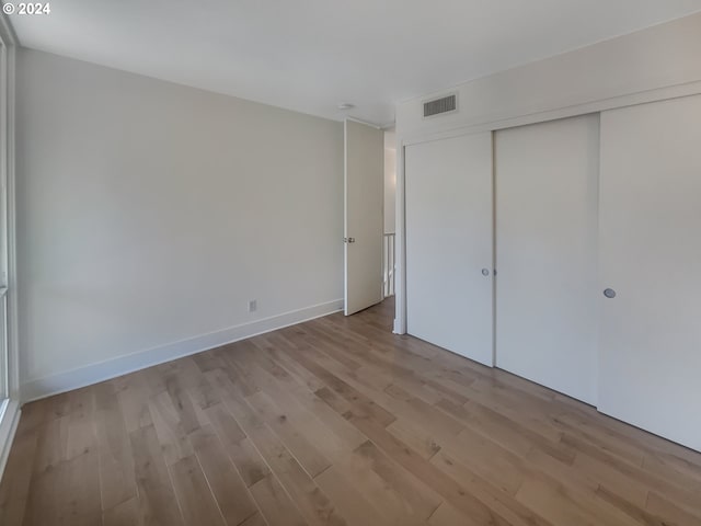 unfurnished bedroom with a closet and light hardwood / wood-style flooring