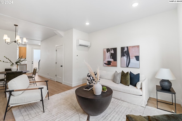 living room with light wood-type flooring, an AC wall unit, and a notable chandelier